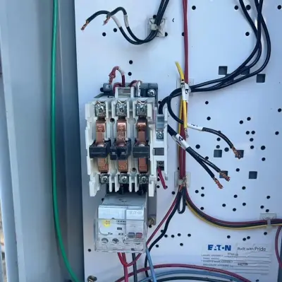 Open control panel with the three-phase motor starter for a water pump