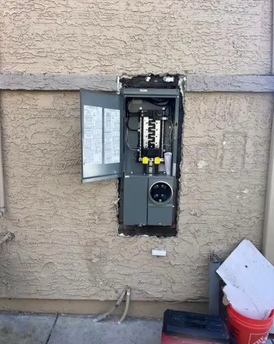 The new 125-amp panel installed with its door open and breakers in place
