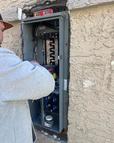An electrician wiring the new panel set into the wall